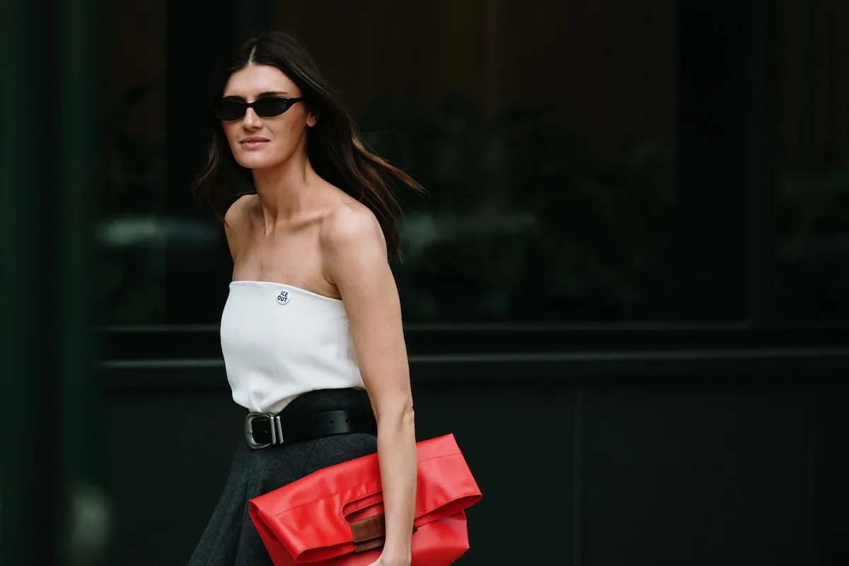 Wyniki finansowe LPP Q1 2026. Kobieta w minimalistycznej stylizacji z czarną spódnicą, białym topem i czerwoną torebką. Nowoczesny look inspirowany trendami fashion i stylem miejskim.