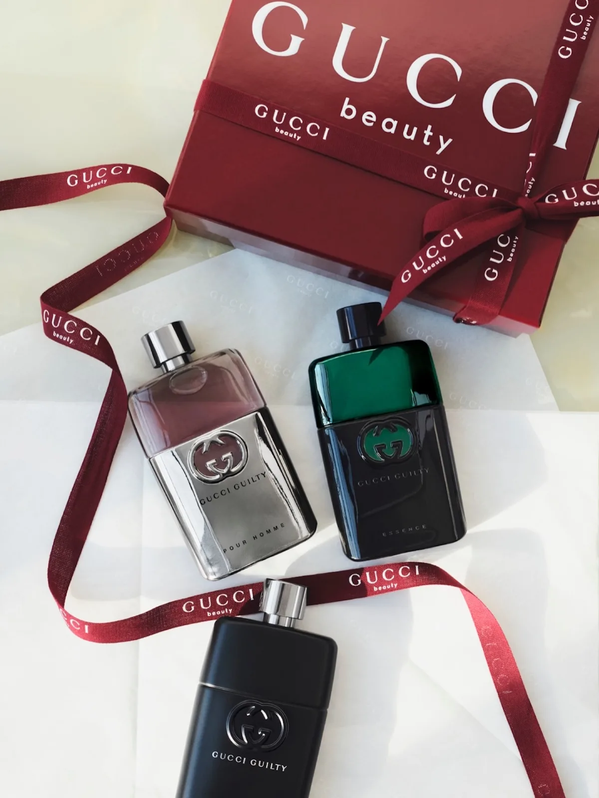 Perfumy Gucci Guilty zaprezentowane obok czerwonych opakowań i wstążek z logo Gucci Beauty. L’Oréal przejmie rozwój i dystrybucję perfum oraz kosmetyków Gucci Beauty, a Coty otrzyma około 400 mln dolarów rekompensaty.