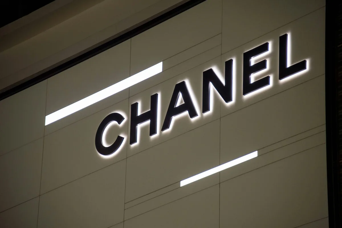 Podświetlane logo Chanel na jasnej ścianie butiku luksusowej marki. Francuski dom mody zajął pierwsze miejsce w rankingu BoF Careers i został uznany za najbardziej pożądanego pracodawcę w branży mody w 2026 roku.