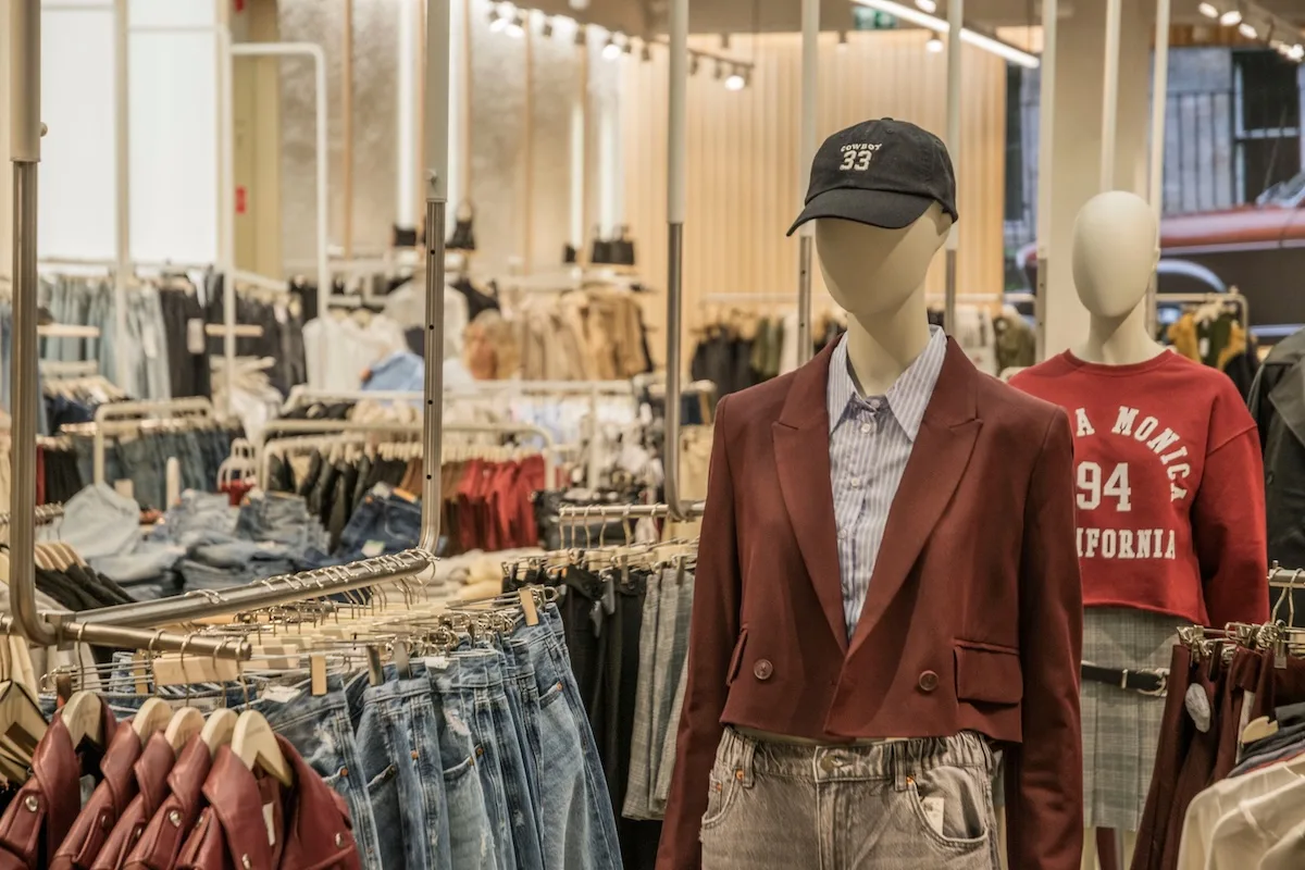 Primark obniża ceny setek produktów. Na zdjęciu wnętrze sklepu stacjonarnego primark - widoczne manekiny w modnych ubraniach oraz wieszaki z ubraniami.