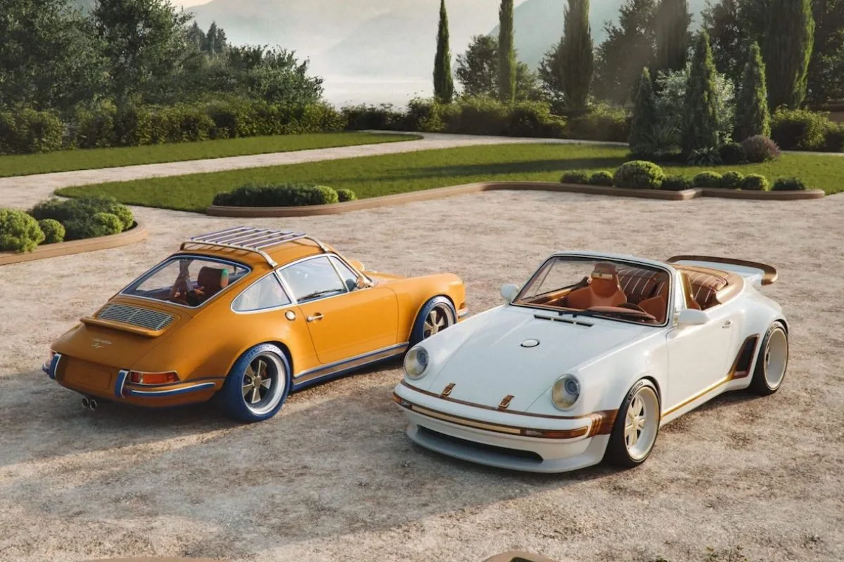 Louis Vuitton Singer Porsche 911. Dwa Porsche 911 stworzone w ramach współpracy Louis Vuitton i Singer ustawione obok siebie na tle zielonego ogrodu i gór. Po lewej znajduje się model w ciepłym, szafranowo-brązowym kolorze z bagażnikiem dachowym, a po prawej jasne Porsche 911 z otwartym nadwoziem, brązowymi detalami i szerokimi nadkolami.