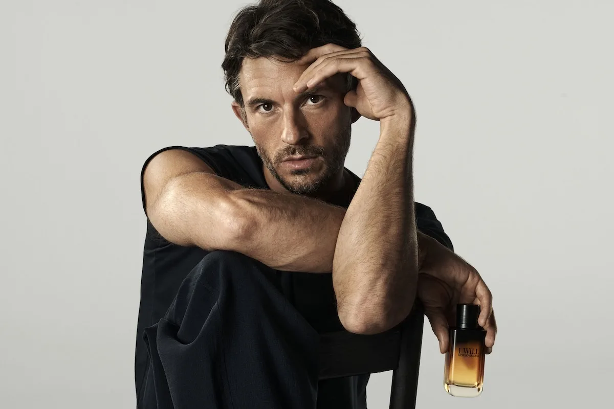 Armani I will - nowe męskie perfumy od ponad 20 lat. Twarzą Jonathan Bailey - na zdjęciu z kampanii trzymający flakon perfum.