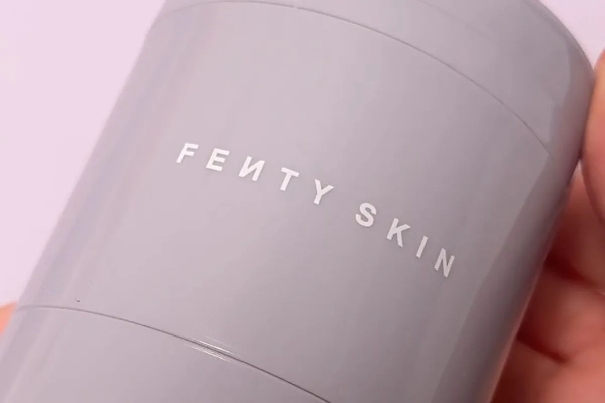 Zbliżenie na opakowanie płatków pod oczy Fenty Skin Dew N Plump Fresh-Sliced Hydrogel Eye Patches w szarym, cylindrycznym dozowniku.