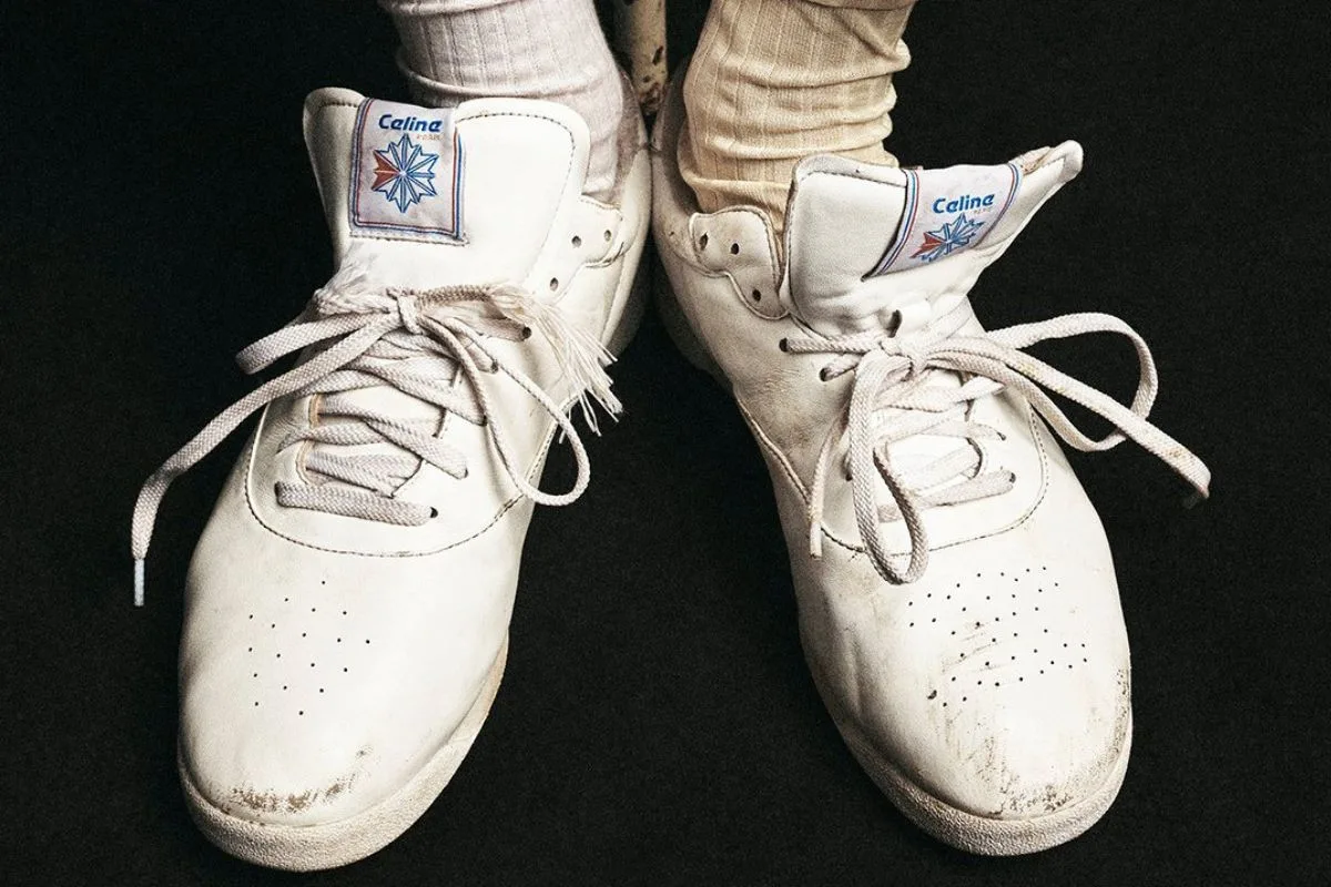 Zbliżenie na białe sneakersy Celine/Reebok Freestyle x charakterystycznym logo na językach, jasnymi sznurowadłami i perforowanymi noskami. Buty zajęły trzecie miejsce w rankingu najgorętszych produktów Lyst Index Q3 2026.