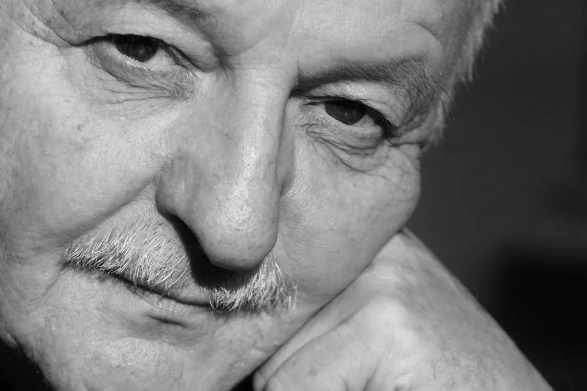 Czarno-biały portret Alberta Masottiego, byłego prezesa La Perli. Zbliżenie twarzy z siwym wąsem; przedsiębiorca podpiera policzek dłonią, spoglądając w dół.