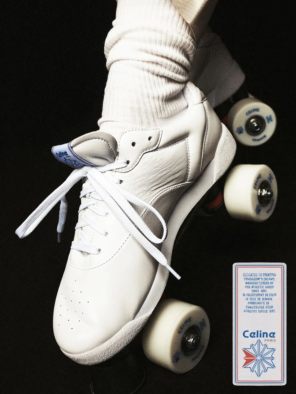 Białe sneakersy Celine/Reebok Freestyle Lo ze skórzaną cholewką i sznurowadłami, sfotografowane na deskorolce z kółkami ozdobionymi logo Celine.