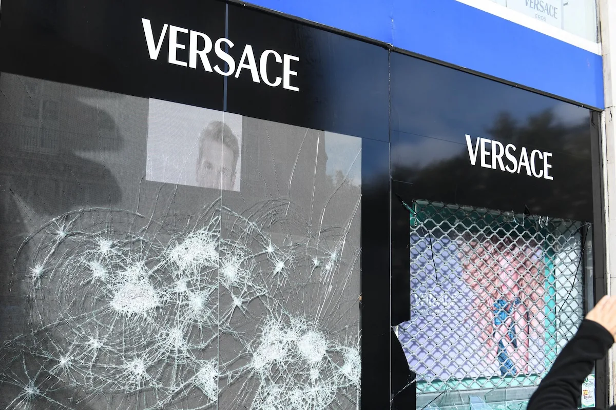 Rozbita szyba po napadzie na sklep Versace we Francji. Skradzione produkty zalały Vinted