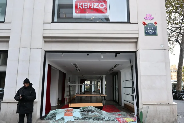 Zniszczony butik Kenzo przy Rue Duphot w Paryżu. Wybita witryna, potłuczone szkło na chodniku i niemal pusty lokal po splądrowaniu sklepu.